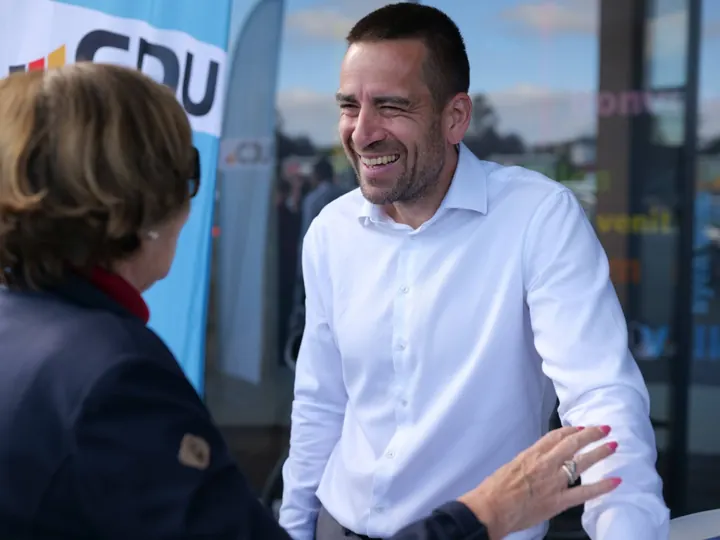 Daniel Phiesel lacht im Gespräch mit einer Frau.